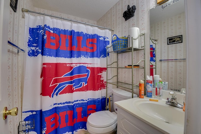 full bath featuring vanity, a shower with curtain, wallpapered walls, a textured ceiling, and toilet