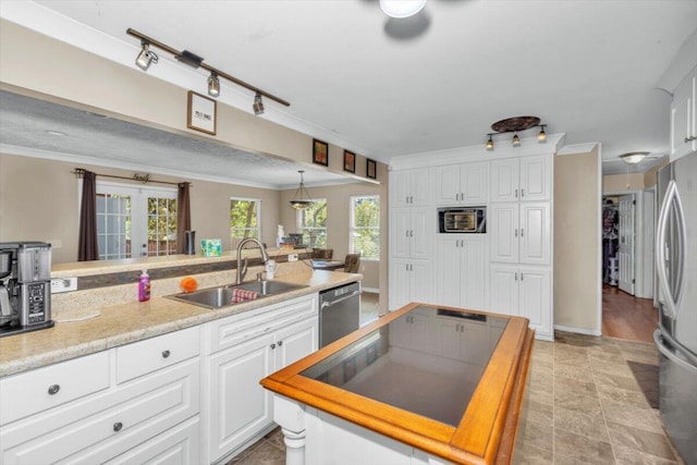 kitchen featuring a sink, stainless steel appliances, white cabinetry, and ornamental molding