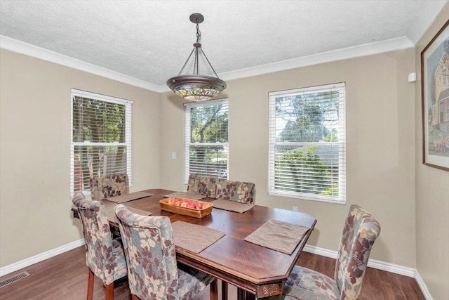 dining room featuring wood finished floors, baseboards, a textured ceiling, and ornamental molding