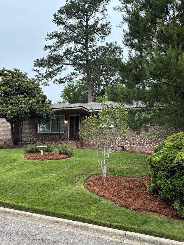 view of front facade featuring a front lawn and brick siding