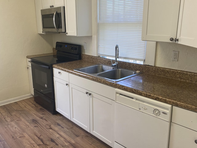 kitchen with dishwasher, dark wood-type flooring, white cabinets, black range with electric stovetop, and sink