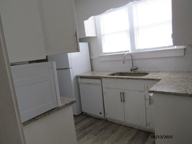 1642 Whitney St, Augusta, GA 30904 - kitchen with dishwasher, backsplash, light wood-style flooring, white cabinets, and light stone countertops