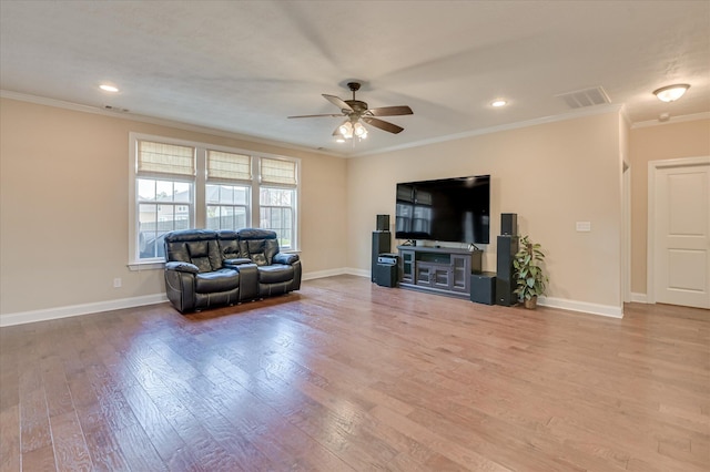 living area featuring crown molding, ceiling fan, wood finished floors, and visible vents