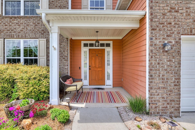 entrance to property featuring brick siding and covered porch