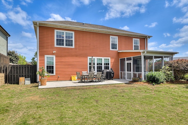 rear view of house with a sunroom, a patio area, fence, and a yard