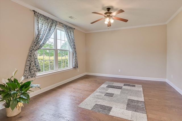 spare room featuring crown molding, baseboards, and ceiling fan