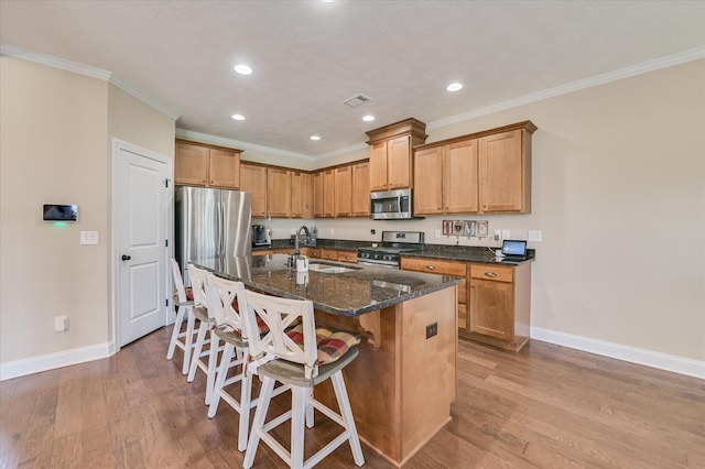 kitchen featuring stainless steel appliances, baseboards, a sink, and light wood-style floors