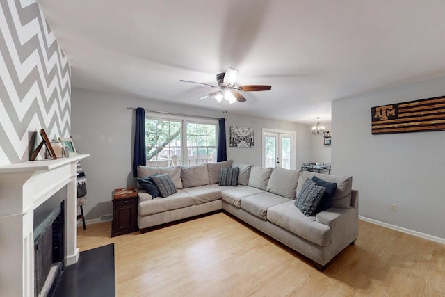 50 Bluff Pointe Way, Aiken, SC 29803 - living area featuring a chandelier, light wood-style floors, a ceiling fan, a fireplace with flush hearth, and baseboards