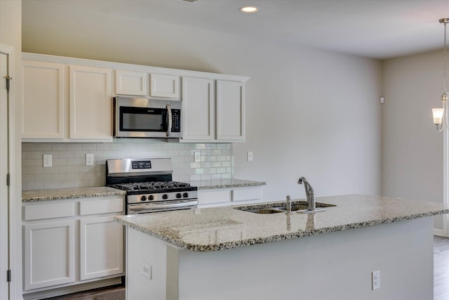 1052 Dietrich Ln, North Augusta, SC 29860 - kitchen with stainless steel appliances, tasteful backsplash, white cabinetry, light stone counters, and hanging light fixtures