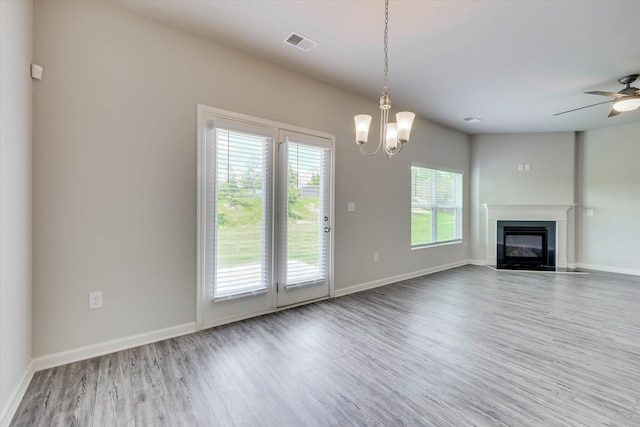 1052 Dietrich Ln, North Augusta, SC 29860 - unfurnished living room with healthy amount of natural light, wood finished floors, a glass covered fireplace, and a chandelier