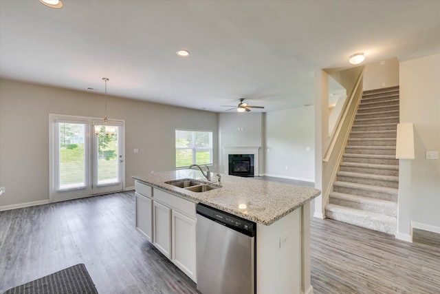 1052 Dietrich Ln, North Augusta, SC 29860 - kitchen with dishwasher, a ceiling fan, a glass covered fireplace, wood finished floors, and light stone counters