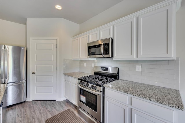 1052 Dietrich Ln, North Augusta, SC 29860 - kitchen with stainless steel appliances, white cabinets, light stone counters, light wood finished floors, and recessed lighting