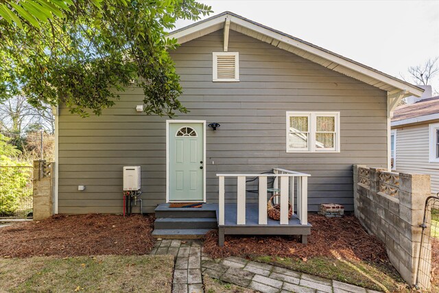 rear view of property featuring fence