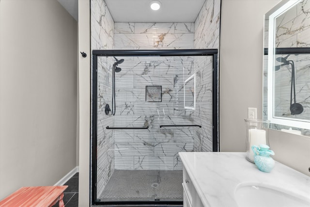 full bathroom featuring vanity, baseboards, and a stall shower