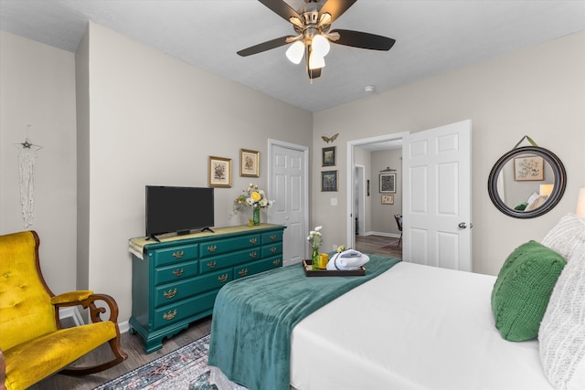 bedroom featuring a ceiling fan, baseboards, and dark wood-type flooring