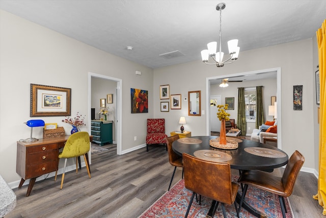 dining space with baseboards, ceiling fan with notable chandelier, and dark wood-style flooring