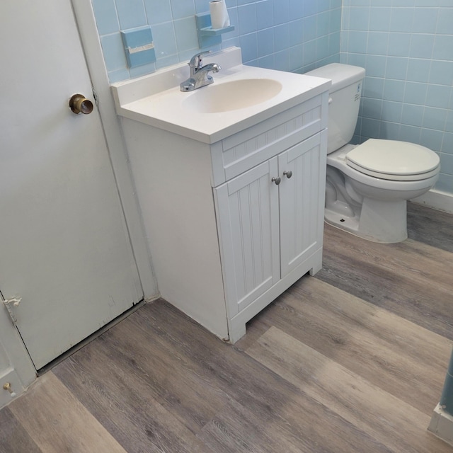 2514 Cascade Dr, Augusta, GA 30904 - half bath featuring wood finished floors, vanity, toilet, tile walls, and tasteful backsplash