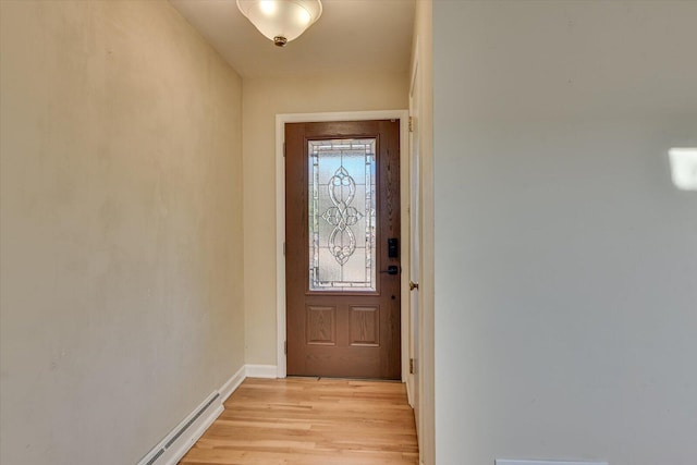 doorway featuring a baseboard heating unit and light hardwood / wood-style flooring