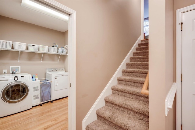 washroom featuring wood-type flooring and washing machine and clothes dryer