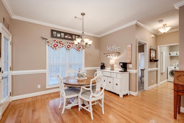 dining area featuring crown molding, washer / clothes dryer, a chandelier, and light hardwood / wood-style floors