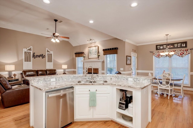 kitchen featuring pendant lighting, stainless steel dishwasher, sink, and an island with sink