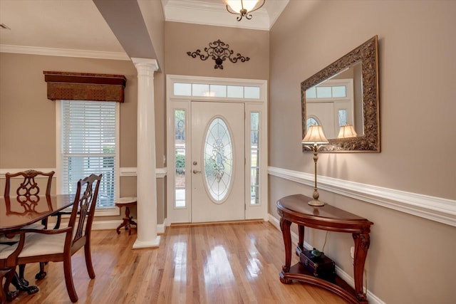 entryway featuring ornate columns, ornamental molding, and light hardwood / wood-style flooring