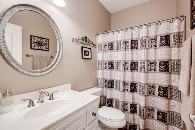 bathroom featuring vanity, curtained shower, and toilet