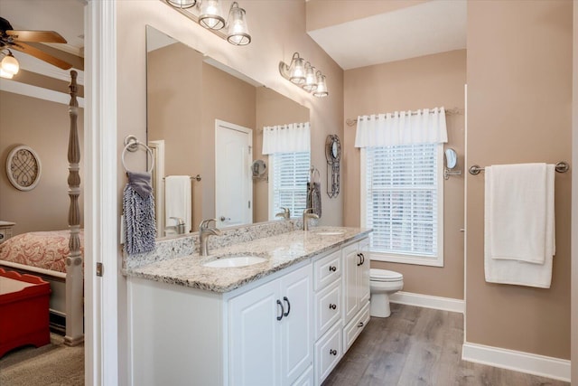 bathroom with vanity, hardwood / wood-style flooring, toilet, and ceiling fan