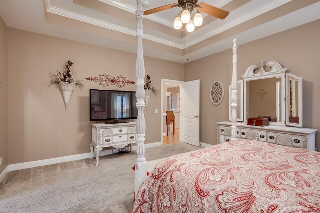 bedroom with a tray ceiling, ornamental molding, light colored carpet, and ceiling fan