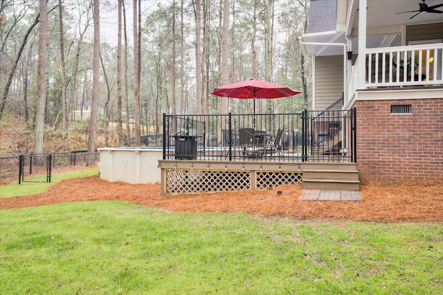 view of yard featuring ceiling fan and a swimming pool side deck