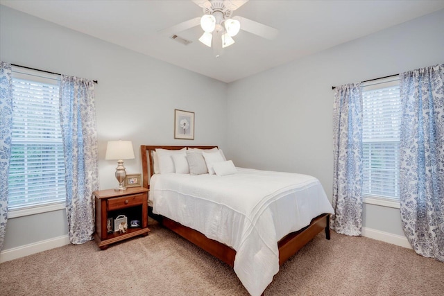 carpeted bedroom with multiple windows and ceiling fan