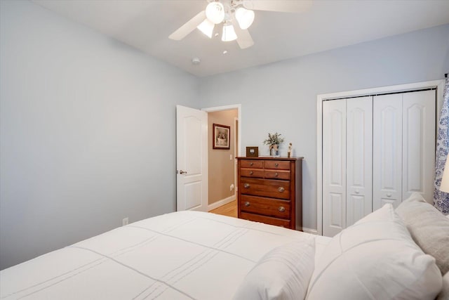 bedroom featuring hardwood / wood-style flooring, ceiling fan, and a closet