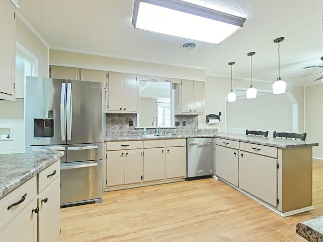 4532 Oakley Pirkle Rd, Martinez, GA 30907 - kitchen with appliances with stainless steel finishes, ornamental molding, light wood-type flooring, decorative backsplash, and hanging light fixtures