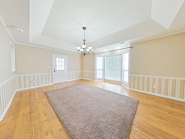 4532 Oakley Pirkle Rd, Martinez, GA 30907 - spare room featuring a tray ceiling, light wood-style flooring, a chandelier, and wainscoting