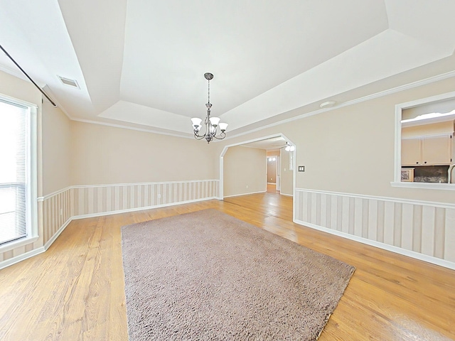4532 Oakley Pirkle Rd, Martinez, GA 30907 - empty room with a tray ceiling, light wood-style flooring, a chandelier, and arched walkways