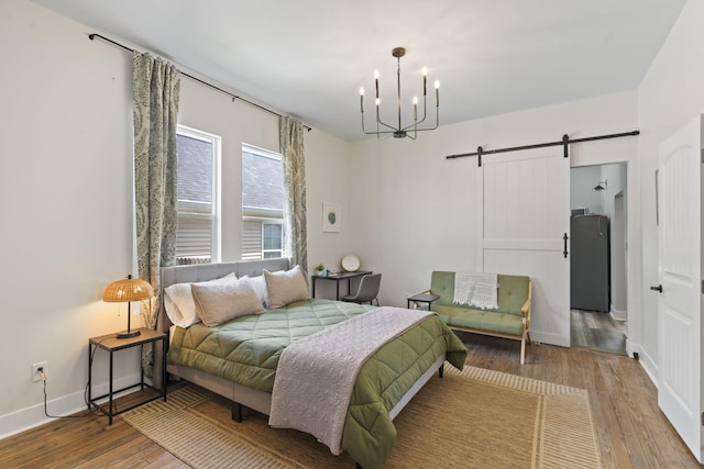 1118 Dantignac St, Augusta, GA 30901 - bedroom with a barn door, wood finished floors, a chandelier, and baseboards