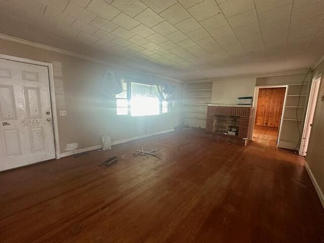 151 Lorrie St, Sardis, GA 30456 - unfurnished living room featuring a brick fireplace, dark hardwood / wood-style flooring, built in features, and ornamental molding