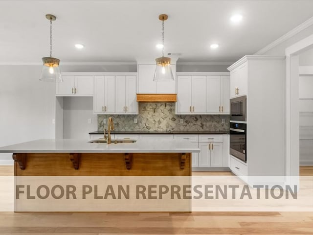 kitchen with a sink, stainless steel appliances, ornamental molding, and white cabinets