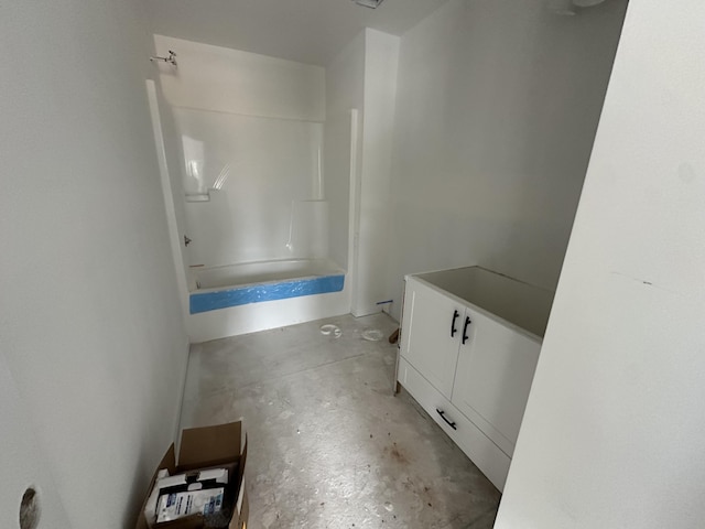 full bathroom featuring vanity, concrete floors, and washtub / shower combination