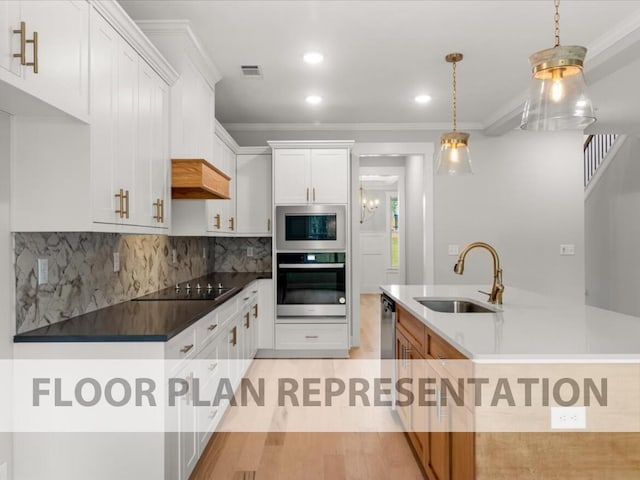 kitchen featuring visible vents, a sink, appliances with stainless steel finishes, crown molding, and backsplash