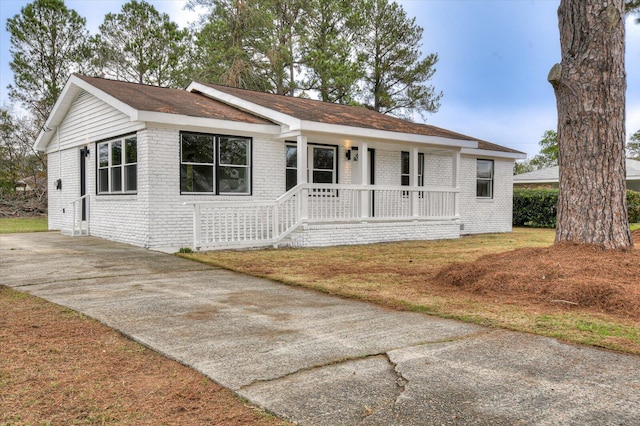 single story home featuring a porch and a front yard