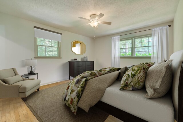 bedroom featuring ceiling fan, a textured ceiling, and hardwood / wood-style flooring