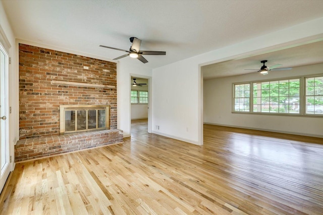 unfurnished living room featuring a textured ceiling, a fireplace, and light hardwood / wood-style flooring