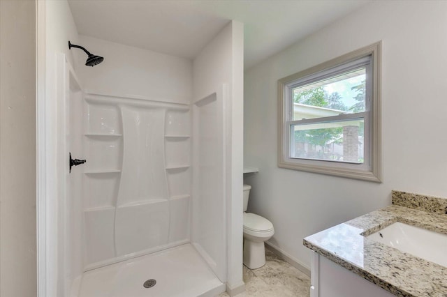 bathroom with a shower, vanity, and toilet