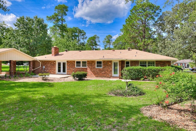 back of property featuring a lawn and french doors