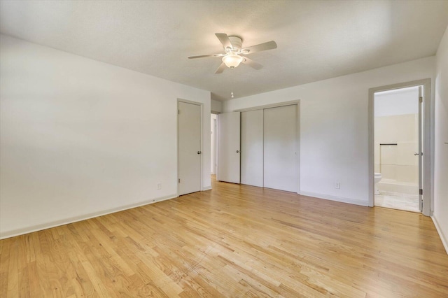 unfurnished bedroom with light hardwood / wood-style floors, ensuite bath, and ceiling fan