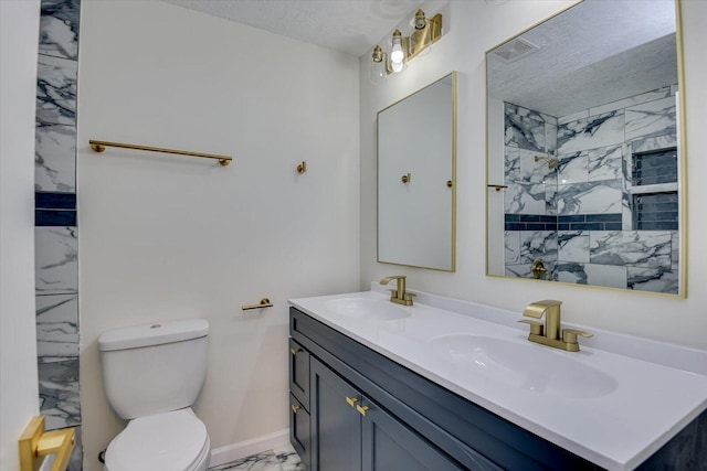 bathroom featuring walk in shower, vanity, toilet, and a textured ceiling