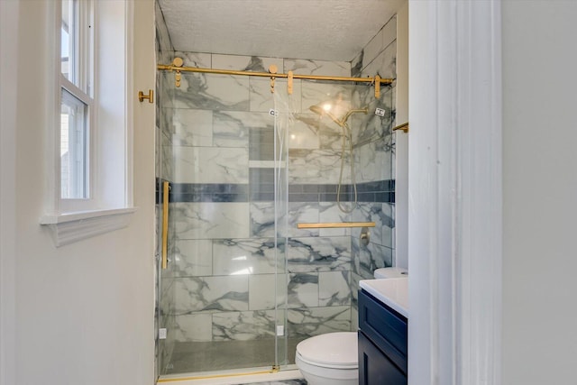 bathroom featuring vanity, a shower with shower door, toilet, and a textured ceiling