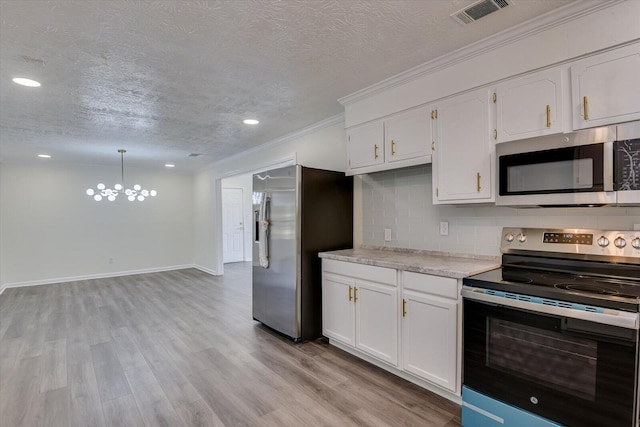 kitchen featuring tasteful backsplash, decorative light fixtures, a textured ceiling, appliances with stainless steel finishes, and white cabinets