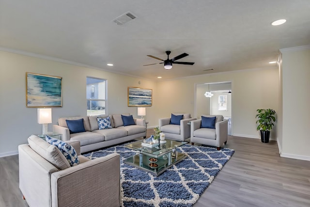 living room featuring wood-type flooring, ornamental molding, and ceiling fan